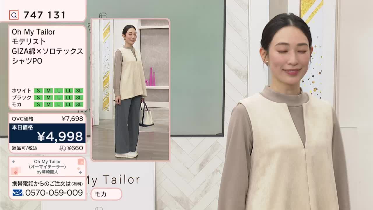 A woman stands on a stage, showcasing a beige sleeveless vest over a tan long-sleeved shirt. The QVC broadcast displays product details and pricing in Japanese next to her. A woman stands on a stage, showcasing a beige sleeveless vest over a tan long-sleeved shirt. The QVC broadcast displays product details and pricing in Japanese next to her.
