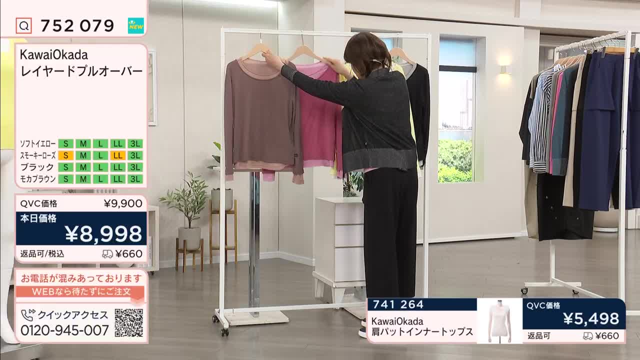 A woman adjusts a taupe layered pullover on a rack while a bright pink one hangs beside it. On a separate rack, a selection of blouses and pants are neatly displayed.