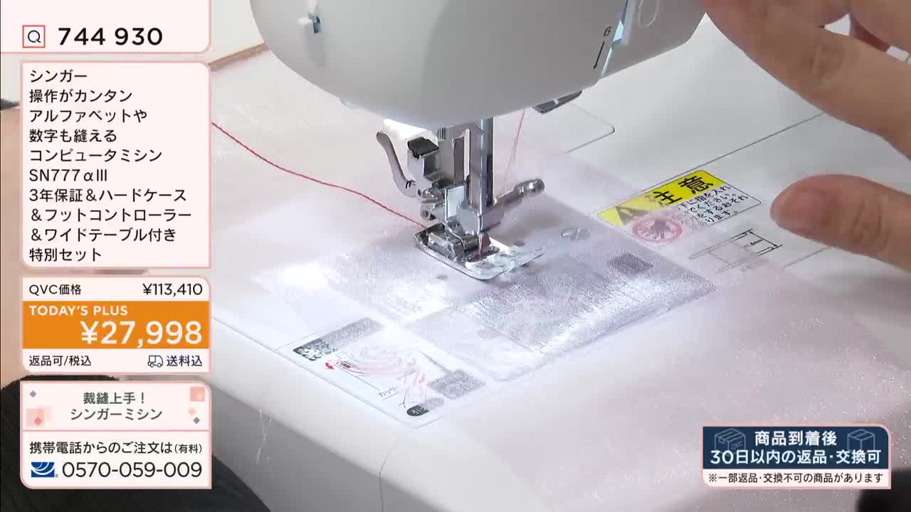 A Singer sewing machine's needle is rapidly stitching through a clear plastic sheet. A hand is guiding the material under the presser foot, demonstrating its operation for a QVC broadcast.