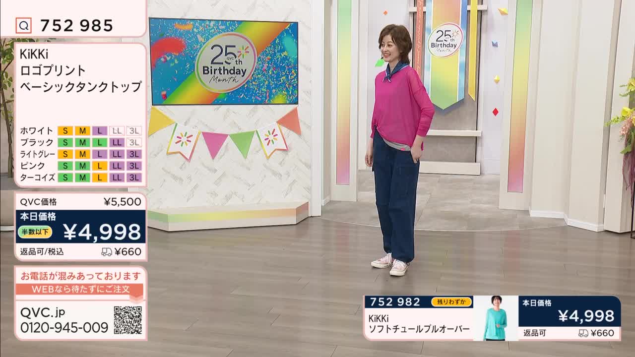 A woman in a bright pink top and dark blue pants stands on a stage. She smiles and gestures with her hands as a graphic displays product information.