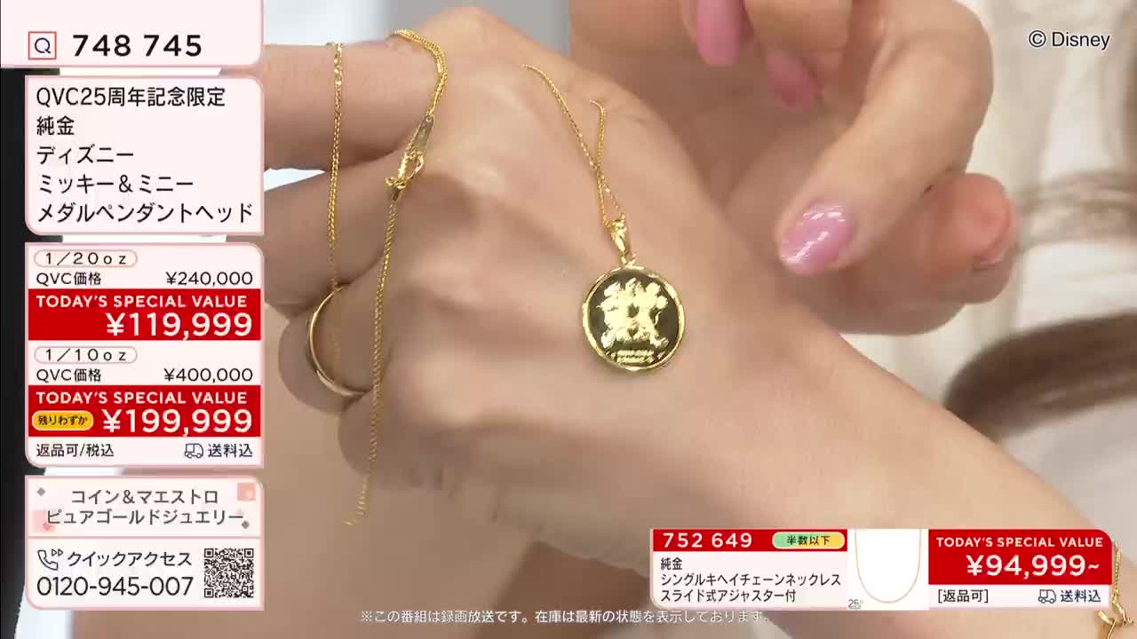 A delicate gold chain, part of a QVC presentation, drapes across a wrist, its pendant a small, round medallion featuring Mickey and Minnie Mouse. The presenter's hand, with its polished pink nails, adjusts the necklace, showcasing the intricate detail of the Disney design.