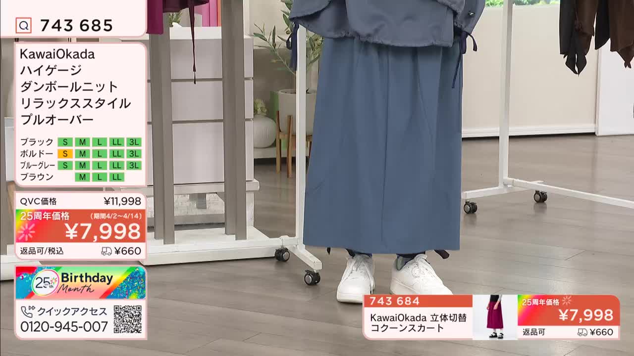 A woman stands in a blue skirt and white sneakers, demonstrating a QVC item. The screen displays pricing and product details in Japanese.