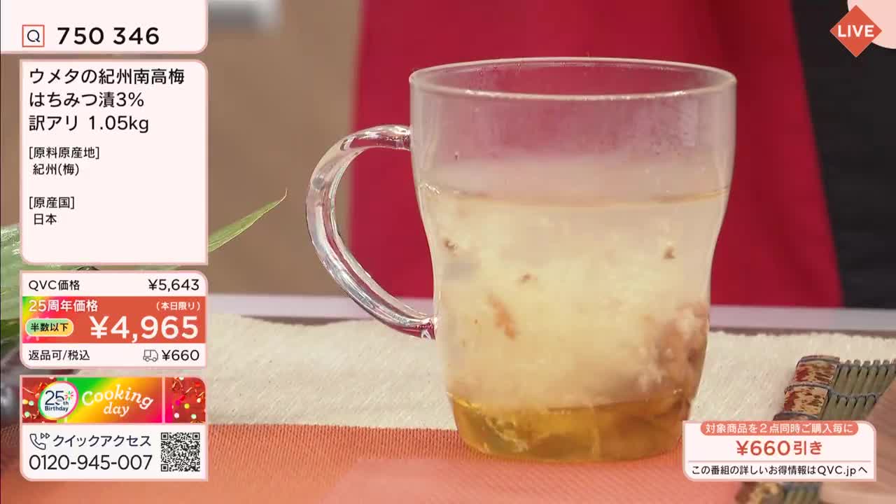 A glass mug holds a pale yellow liquid with pieces of fruit submerged within. The QVC logo is visible on the screen, indicating this is a product being presented for sale.