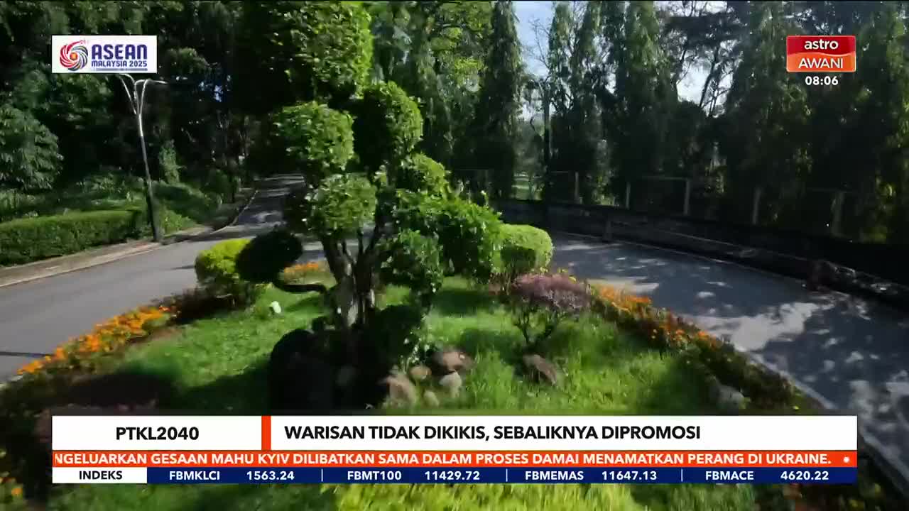 A manicured garden, with a winding road, is the backdrop for a news segment from Astro Awani. The screen displays financial data and a headline about Ukraine.
