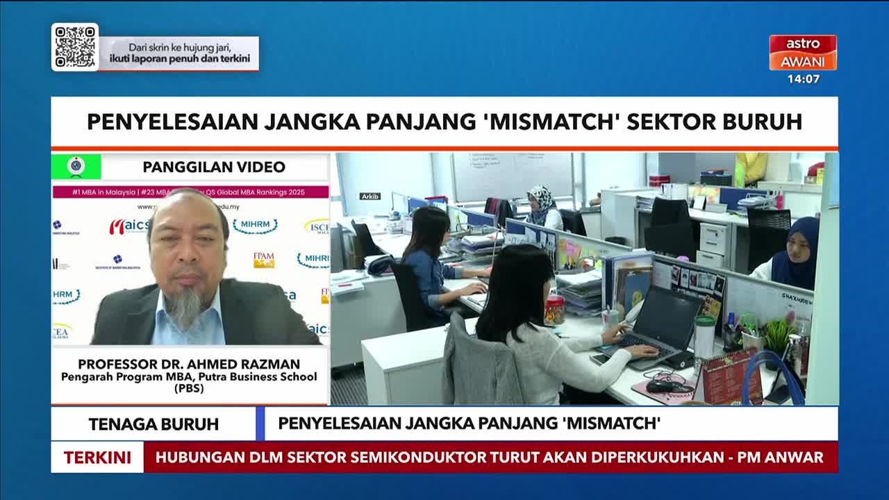 Astro Awani is broadcasting a video call with a professor discussing labor market issues. In the background, people work at their desks in a modern office.
