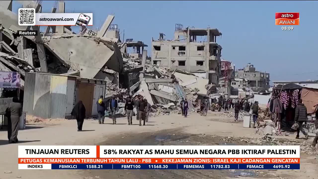 Debris litters the street as people walk past the rubble of what was once a building. The Astro Awani report shows the aftermath of destruction.
