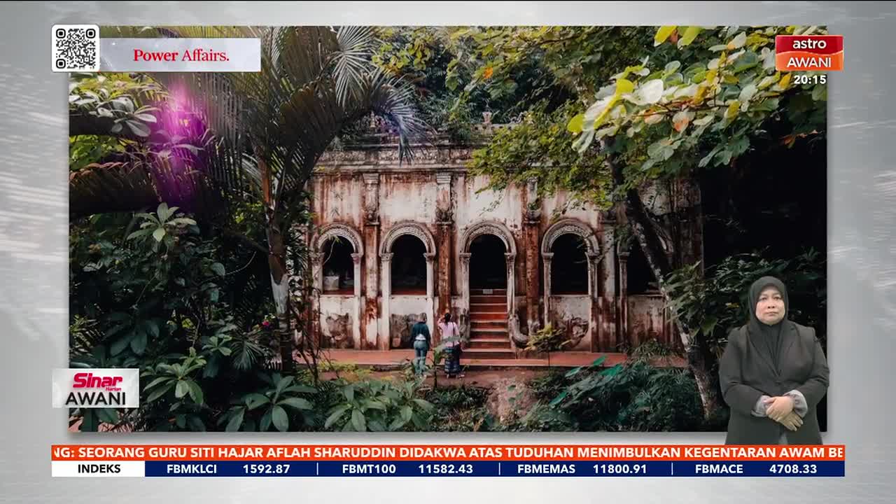 A weathered building, partially obscured by lush greenery, is the backdrop for the Astro Awani broadcast. The news anchor in the studio is reporting on a story, with financial data at the bottom of the screen.
