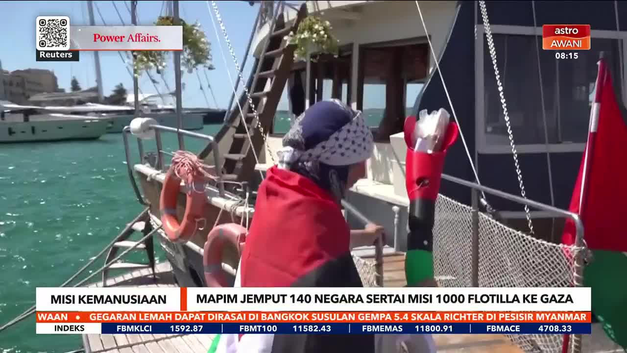 A person draped in a Palestinian flag stands on a boat, looking toward the water.  The scene is being broadcast on Astro Awani, with a headline about a humanitarian mission.
