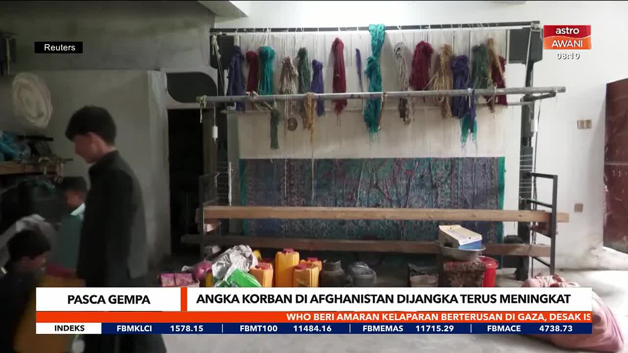 A man and two children stand near a loom, with a partially woven rug visible. The Astro Awani broadcast reports on the aftermath of an earthquake in Afghanistan.
