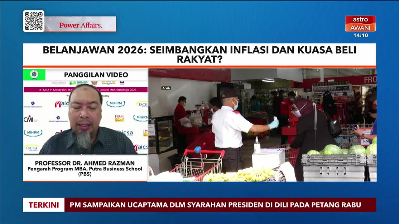 A professor from Putra Business School discusses the 2026 budget on Astro Awani, while a scene of shoppers in a grocery store plays in the background. The broadcast shows the news in Malaysia, with a focus on balancing inflation and purchasing power.
