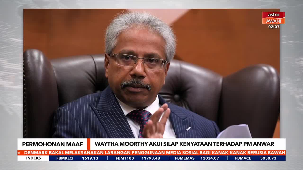 Waytha Moorthy, on Astro Awani, gestures with his hands, speaking directly into the camera. The chyron below announces his apology regarding a statement about PM Anwar.
