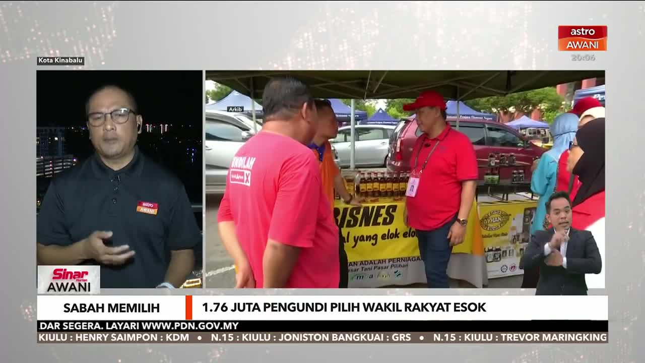 Astro Awani's coverage of the Sabah election features a reporter speaking from a dark outdoor setting. On the right, a man in a red hat and shirt stands behind a table displaying bottles, while another man signs.
