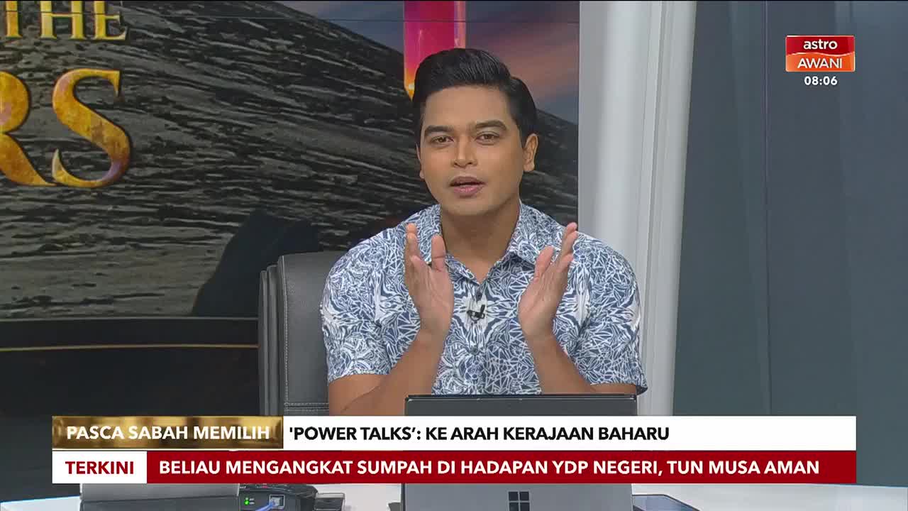 A man in a patterned shirt gestures with both hands as he speaks. The Astro Awani logo and time are visible in the corner, with headlines about Sabah's election results displayed below.
