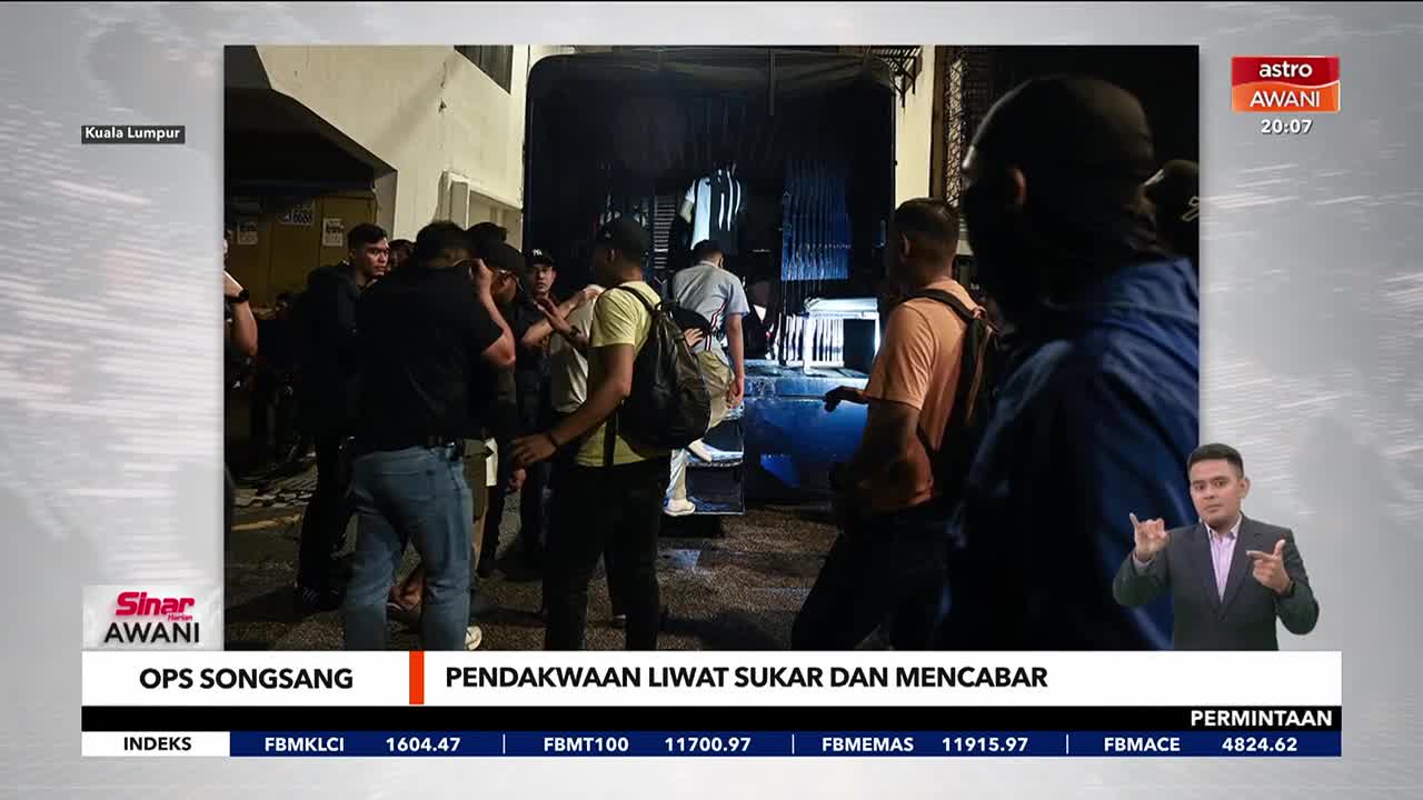 A group of men stand near a dark doorway, some gesturing and talking. The Astro Awani broadcast shows a news anchor in the corner, reporting on an "OPS SONGSANG" in Kuala Lumpur.
