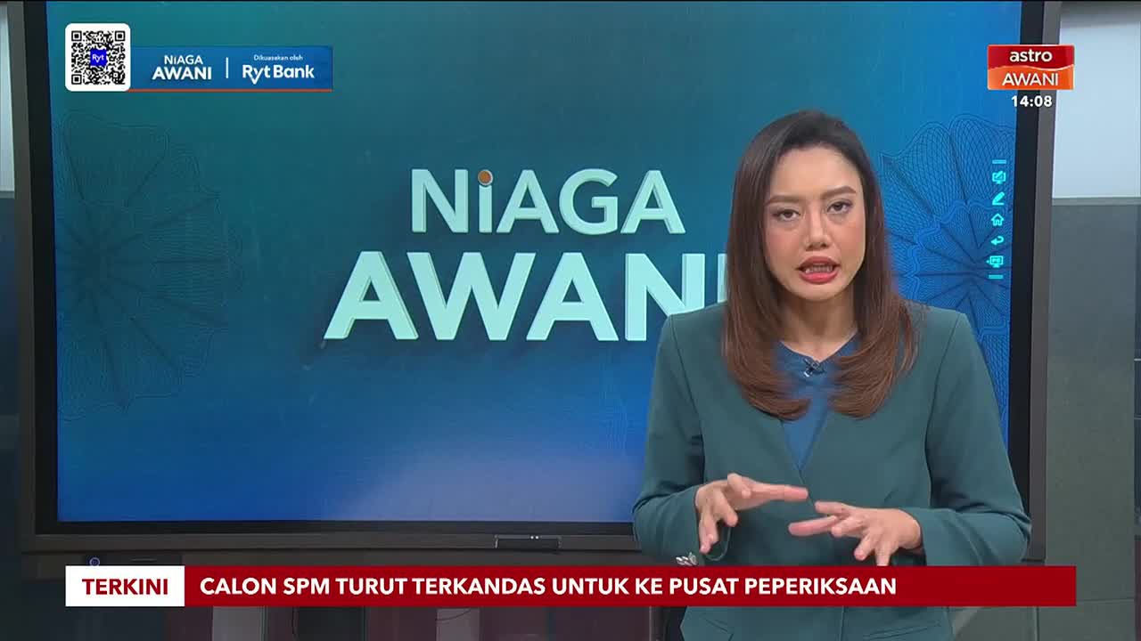A woman in a green blazer gestures with her hands as she speaks, the "Niaga Awani" logo displayed behind her. The Astro Awani logo and time are visible in the upper right corner.
