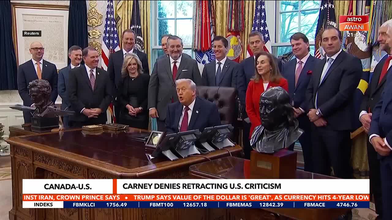 Donald Trump sits behind a large desk, speaking to a group of men and women standing behind him. A banner from Astro Awani, a Malaysian news outlet, is visible in the upper right corner. Donald Trump sits behind a large desk, speaking to a group of men and women standing behind him. A banner from Astro Awani, a Malaysian news outlet, is visible in the upper right corner.