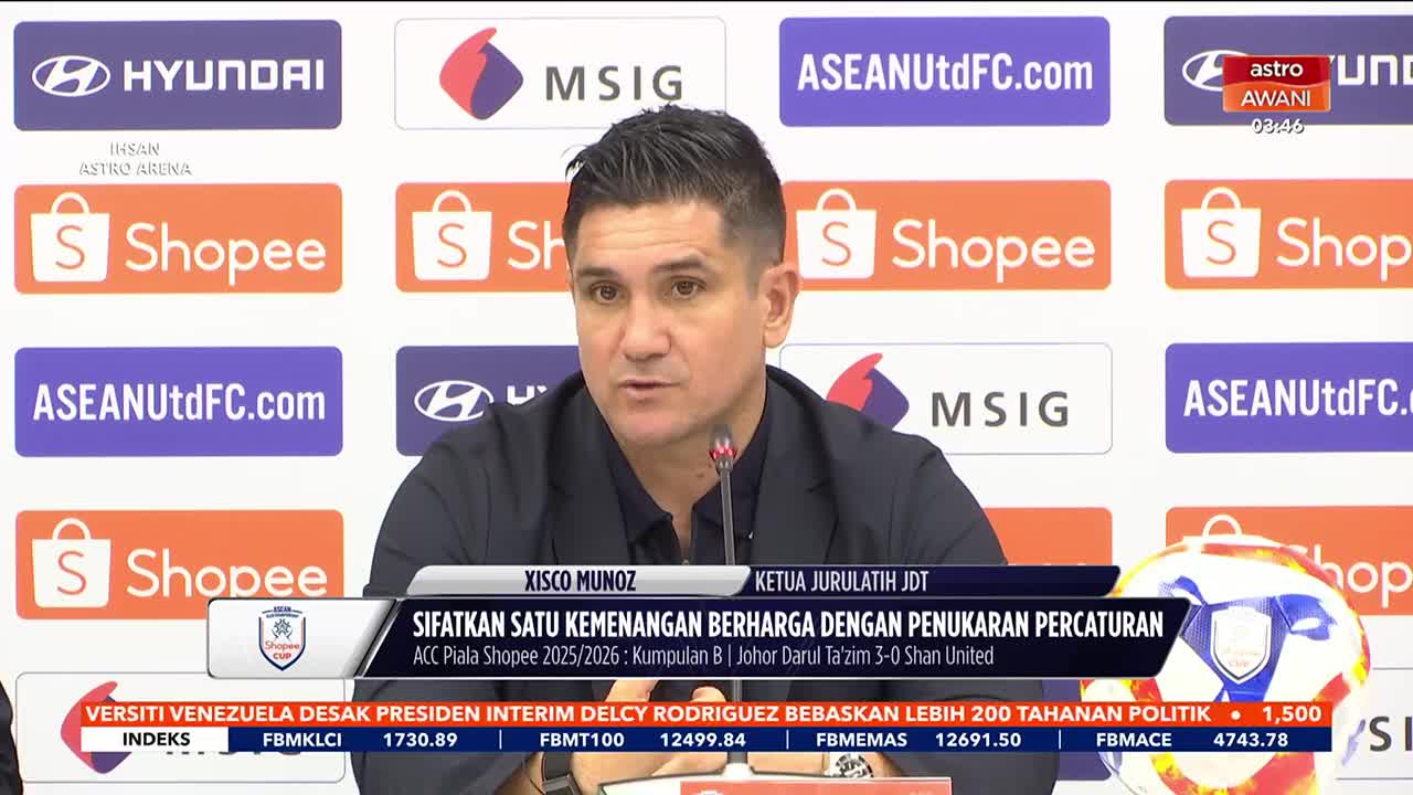 The coach, Xisco Munoz, speaks into a microphone, his expression serious. Behind him, a wall of logos from sponsors like Shopee and Hyundai is visible, with the Astro Awani logo in the corner. The coach, Xisco Munoz, speaks into a microphone, his expression serious. Behind him, a wall of logos from sponsors like Shopee and Hyundai is visible, with the Astro Awani logo in the corner.