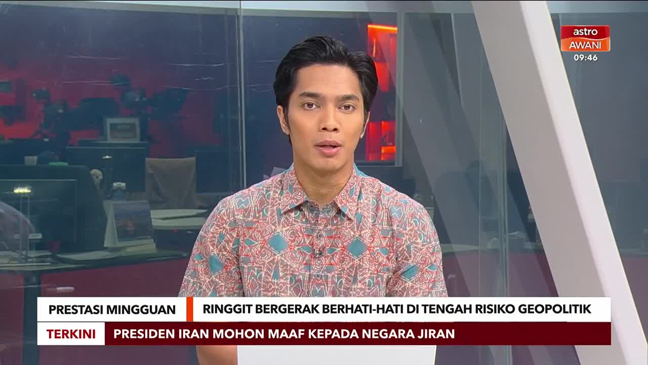 A man in a patterned shirt speaks directly to the camera in a studio setting. Behind him, a screen displays the Astro Awani logo and the time.