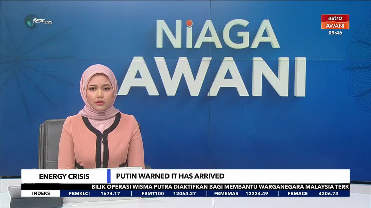 A news anchor in a pink hijab sits at a desk, reporting live from Astro Awani. The screen behind her displays "Niaga Awani" and a ticker with stock market updates relevant to Malaysia.