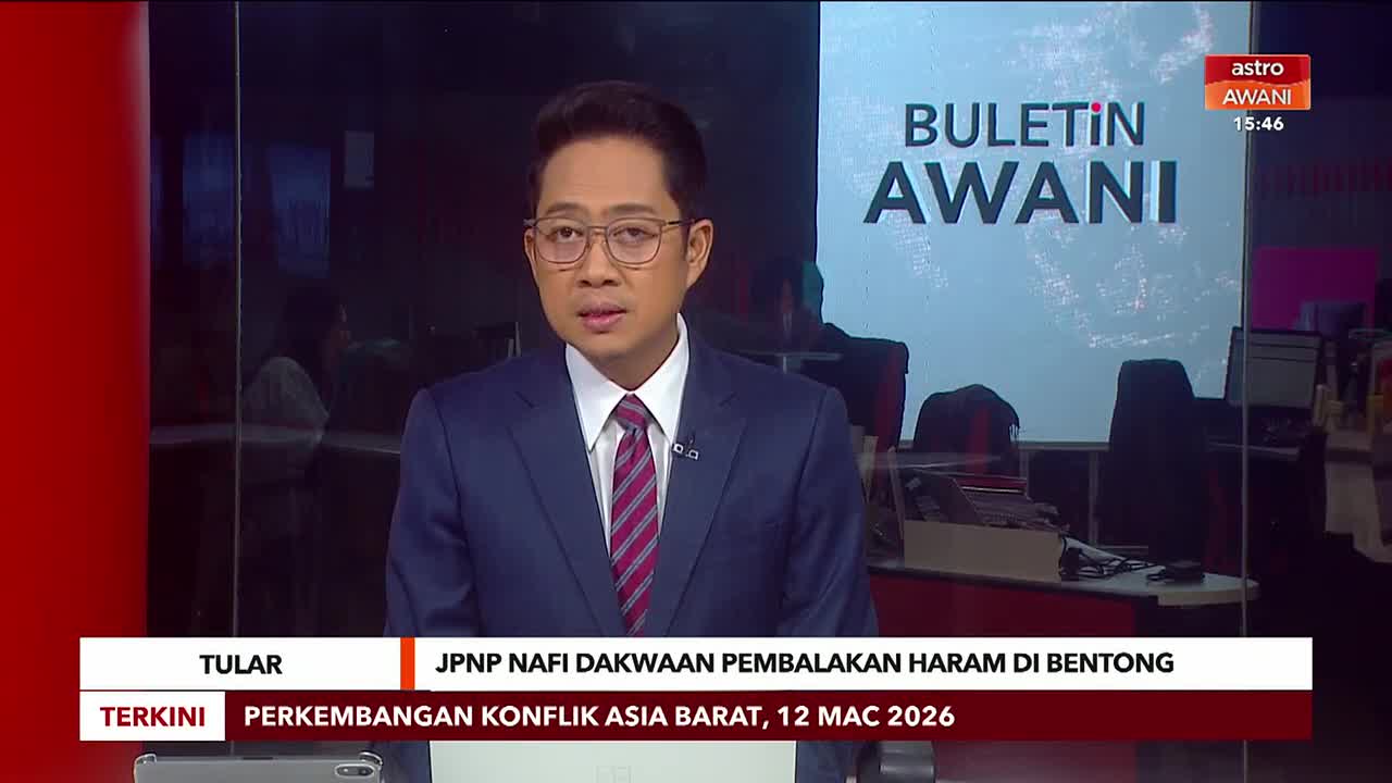 A man in a suit stands before a screen displaying "BULETIN AWANI." Text below him reads "JPNP NAFI DAKWAAN PEMBALAKAN HARAM DI BENTONG."
