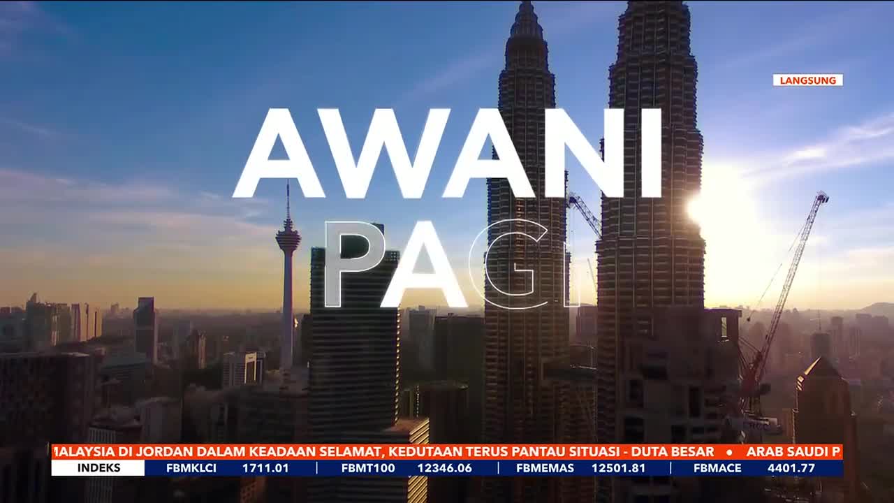 The sun glints off the Petronas Towers as the "AWANI PAGI" title fills the screen. Cranes stand tall against the hazy morning sky, hinting at ongoing construction in Kuala Lumpur.