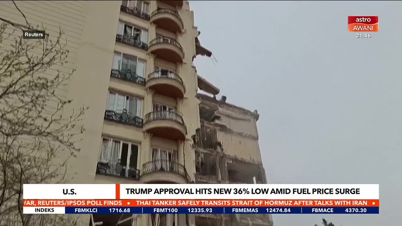 A section of a tall building has collapsed, leaving exposed floors and twisted metal against a gray sky. News graphics from Astro Awani overlay the scene, with headlines about U.S. approval ratings and fuel prices.