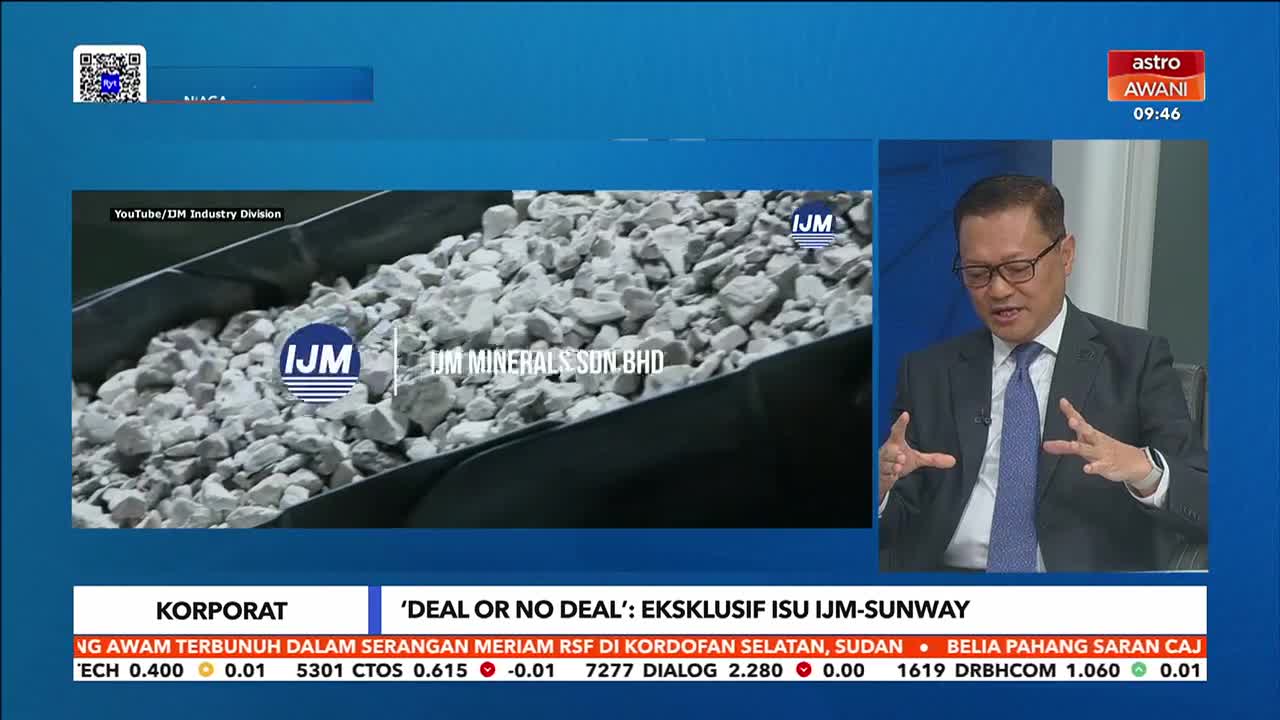 A man in a suit gestures animatedly while speaking on Astro Awani. Beside him, a video shows a conveyor belt filled with light-colored rocks, bearing the IJM Minerals logo.