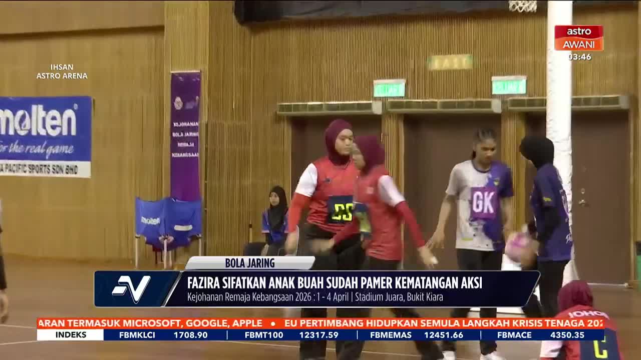 Players in red jerseys are moving towards the center of the court. A player in a purple and white jersey with "GK" on it stands ready.