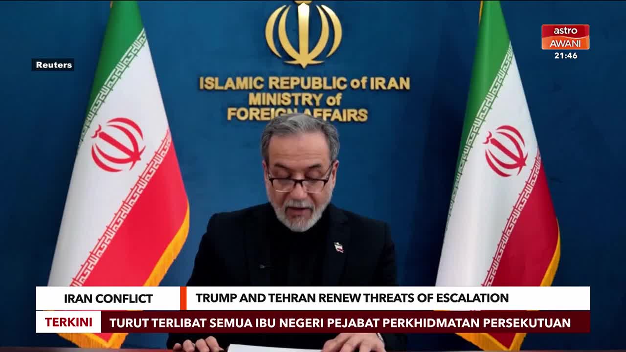 A man with glasses and a beard speaks at a podium, flanked by Iranian flags. A news ticker from Astro Awani displays "IRAN CONFLICT TRUMP AND TEHRAN RENEW THREATS OF ESCALATION."