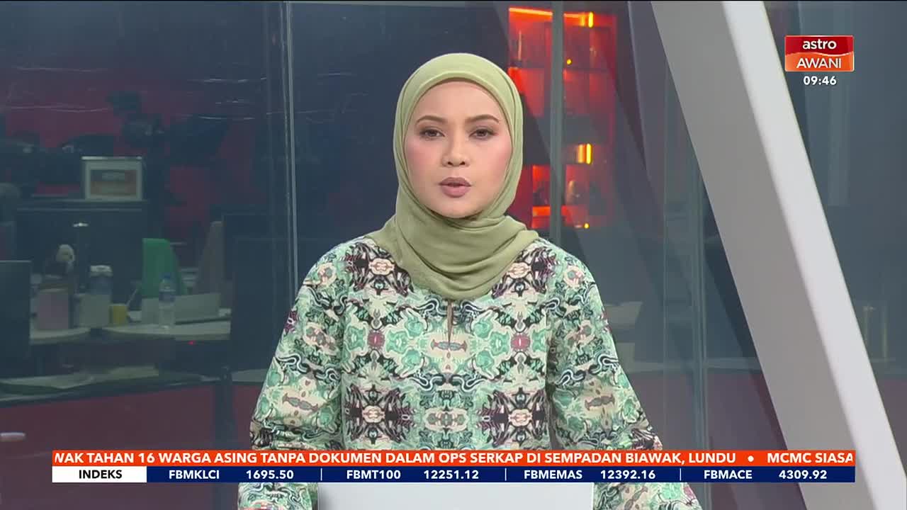 A woman in a light green hijab and patterned top speaks directly to the camera. A ticker displaying Malaysian financial data scrolls across the bottom of the screen, and the Astro Awani logo is visible in the upper right corner.