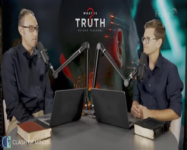 Two men, each with a microphone, sit at a table with laptops and books, engaged in a discussion. The Firstlight logo is visible, and the backdrop features the words "What is Truth."
