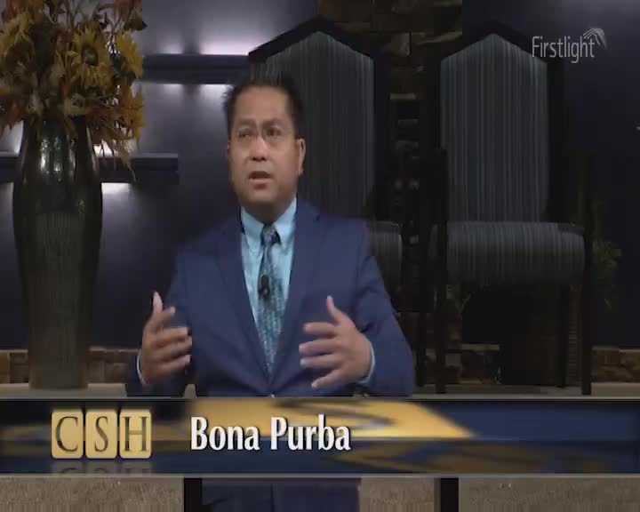 Bona Purba, identified on the lower third, gestures with both hands while speaking. Behind him, a Firstlight logo is visible, and two large chairs are in the background.
