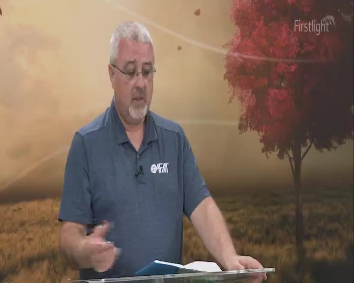 A man with glasses and a grey beard gestures with his left hand as he speaks. The "Firstlight" logo is visible in the top right corner, and a tree is in the background.
