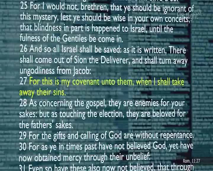 The text on the screen scrolls upwards, revealing verses from Romans. A small "Firstlight" logo is visible in the top right corner. The text on the screen scrolls upwards, revealing verses from Romans. A small "Firstlight" logo is visible in the top right corner.