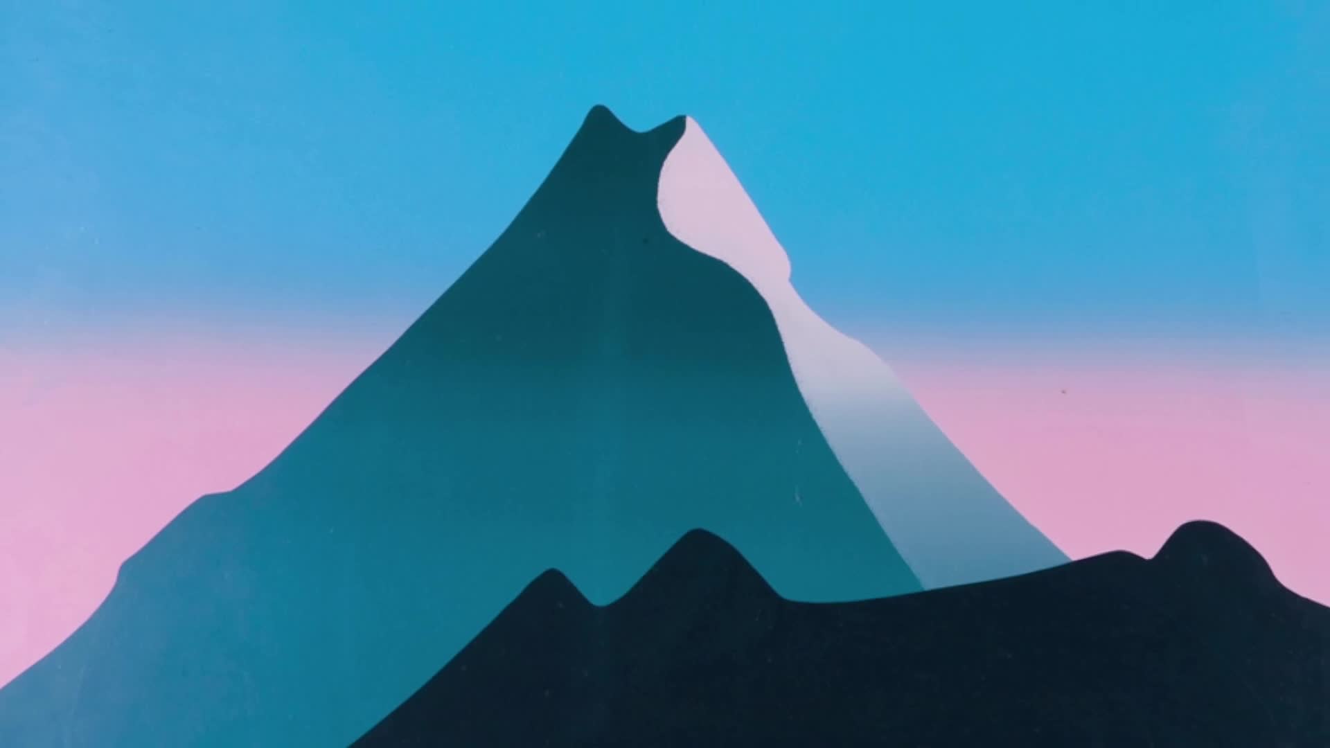 The sky above the peaks is a vibrant gradient of blue to pink. Jagged, dark blue mountains fill the foreground, with a lighter, snow-capped peak rising behind them.