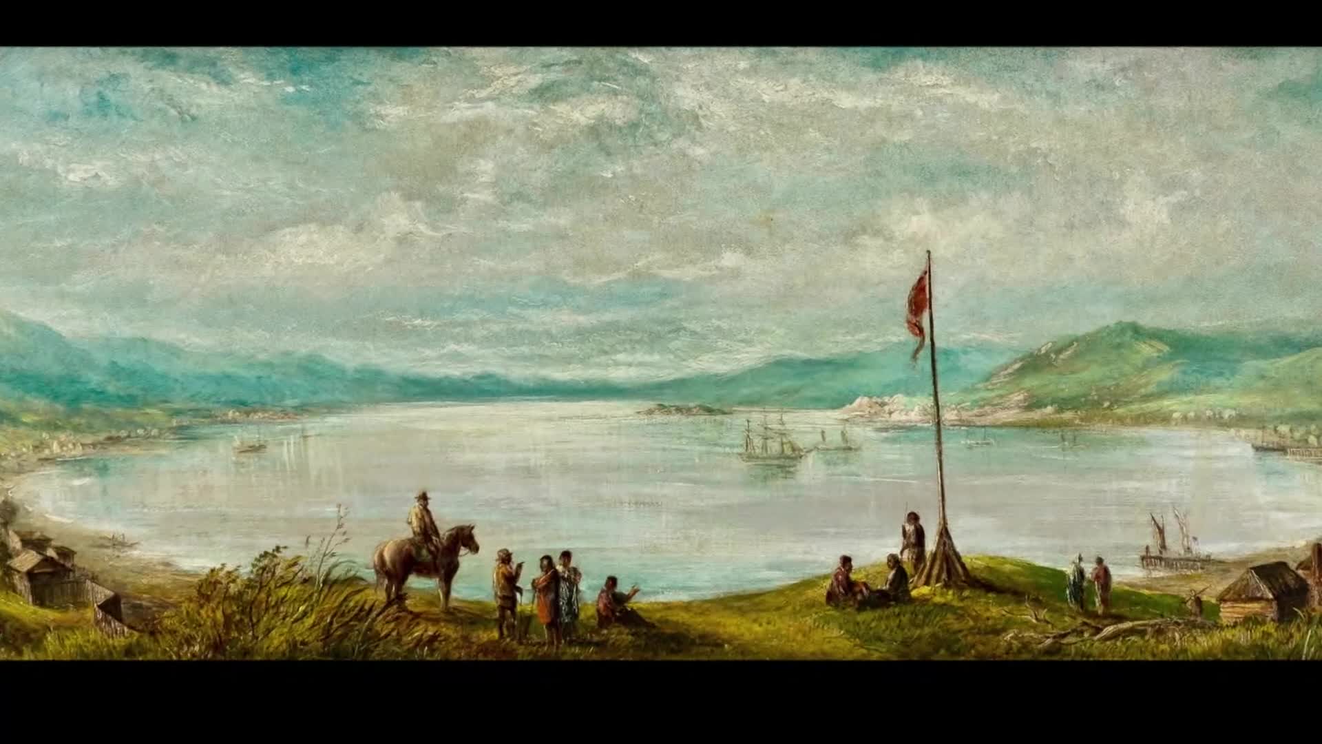 A red flag flies over a bay dotted with sailing ships. People gather on a grassy hill overlooking the water, some on horseback.