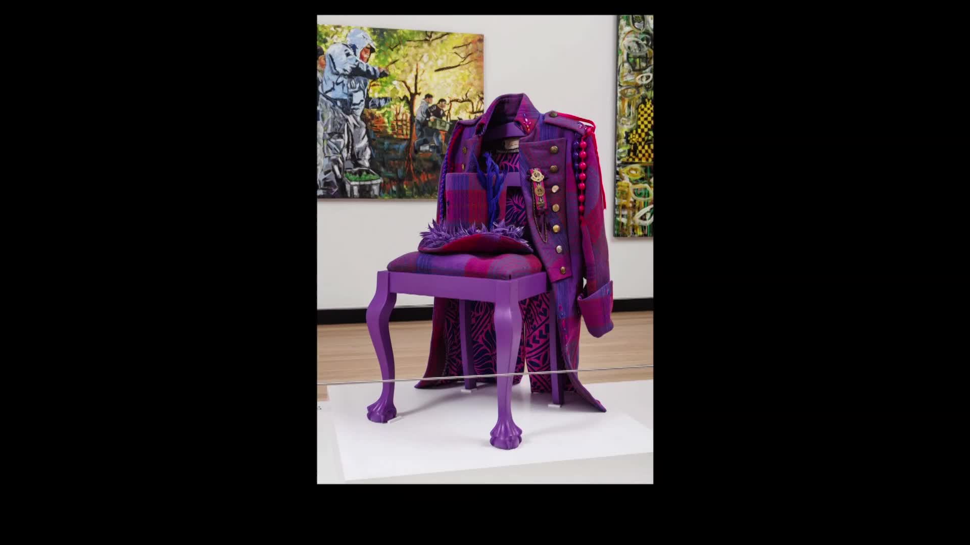 A vibrant purple military-style coat and hat rest on a matching chair. The artwork stands against a backdrop of other paintings.