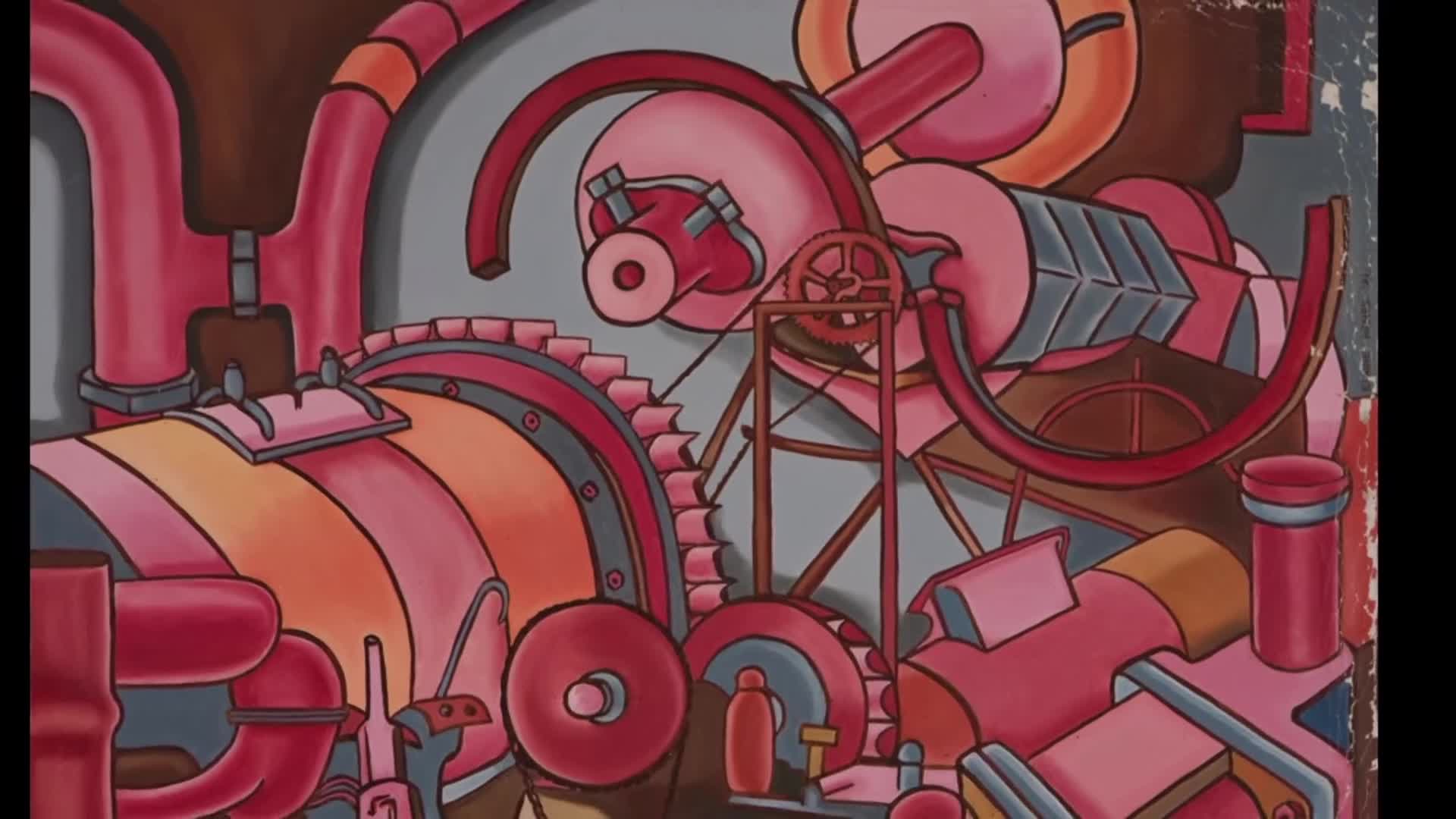 A complex arrangement of pink and orange pipes and gears dominates the frame. A red, curved piece of metal arcs over a set of interlocking cogs.