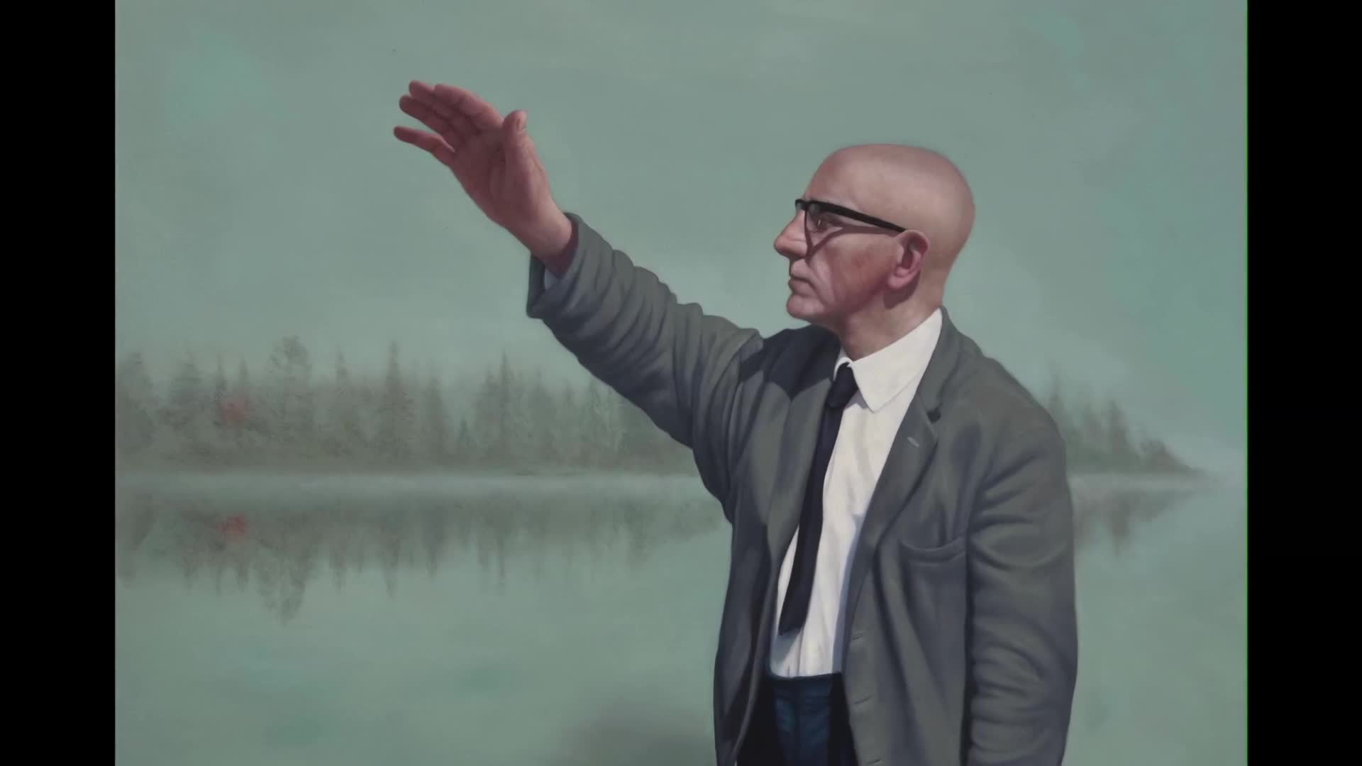 A man in a suit raises his hand, his gaze fixed on something beyond the frame. Behind him, a misty lake reflects a sparse line of trees.