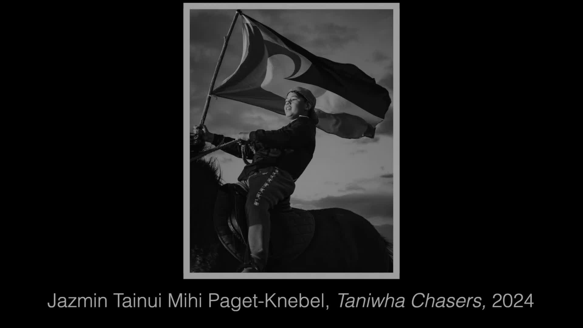 A young person on horseback raises a flag, its fabric rippling against a dramatic sky. This scene, captured in a photograph, evokes a sense of movement and pride.
