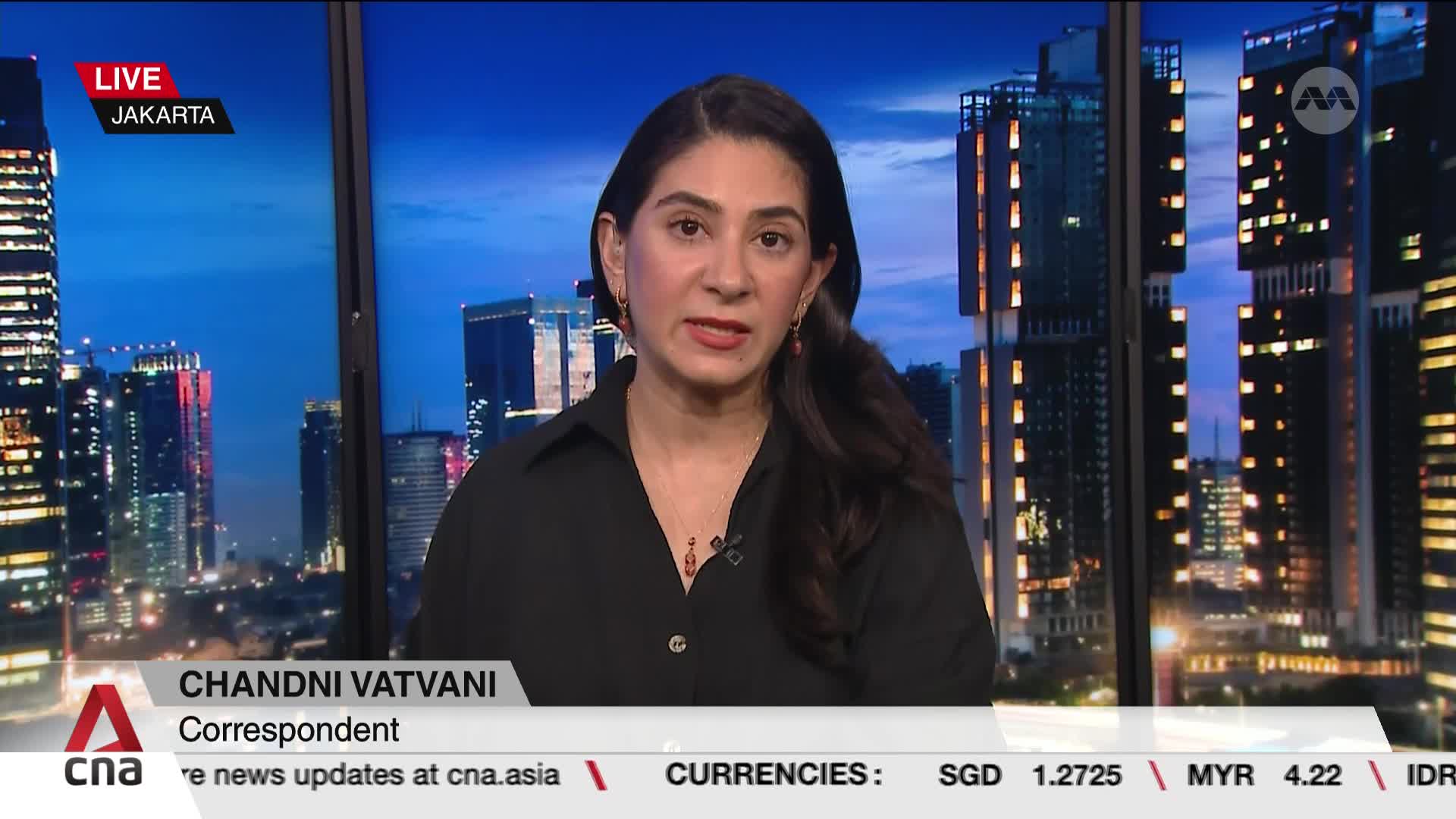Chandni Vatvani, a CNA International correspondent, is speaking directly to the camera from Jakarta, with a cityscape visible behind her. The lower third of the screen displays her name and the news organization's logo, along with currency exchange rates.
