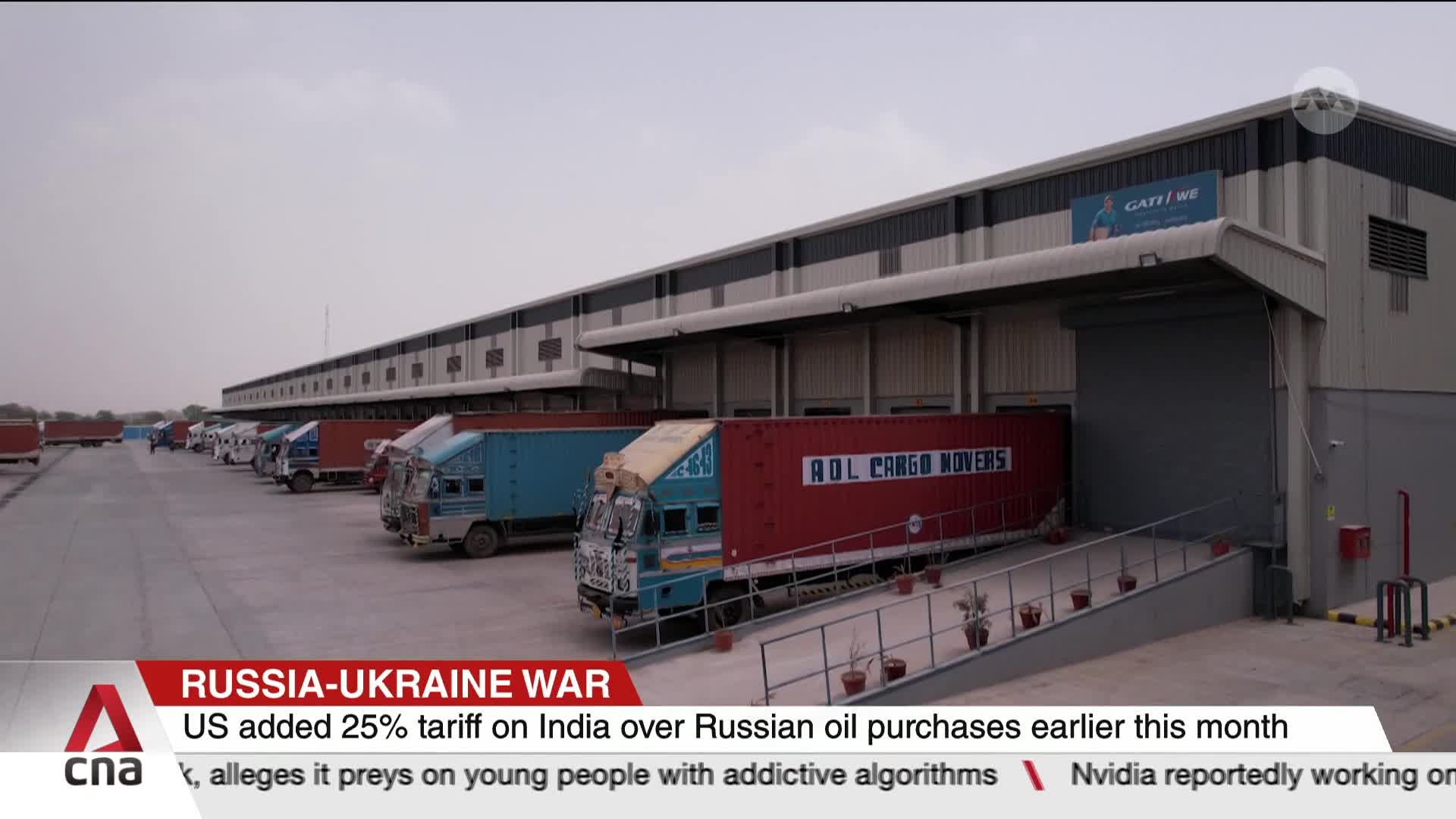 A line of trucks, some with red containers labeled "ADL CARGO MOVERS," are backed up to loading docks. The scene, reported by CNA International, is likely related to the Russia-Ukraine war and its impact on trade.
