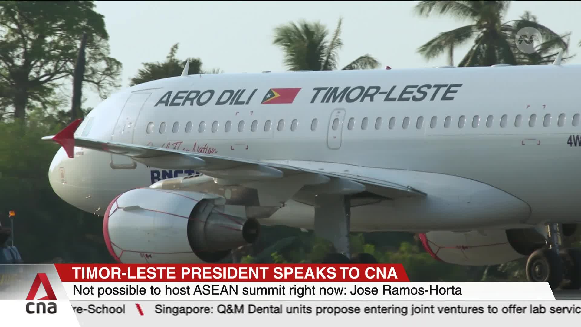 An Aero Dili plane, emblazoned with the Timor-Leste flag, taxis on the tarmac. The CNA International banner reports on the president's statement about the ASEAN summit.
