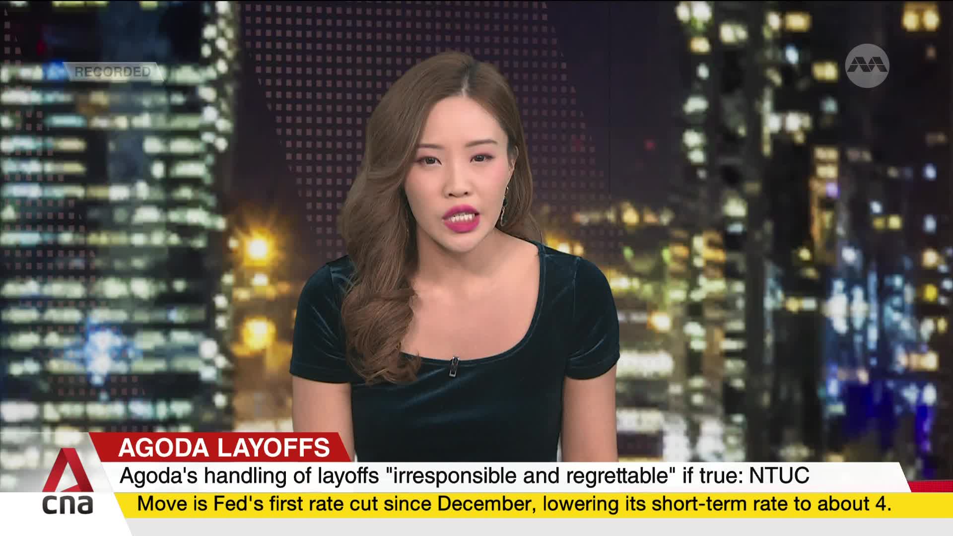 A news anchor in a dark green dress speaks directly to the camera. The CNA International logo is visible, along with a headline about Agoda layoffs.
