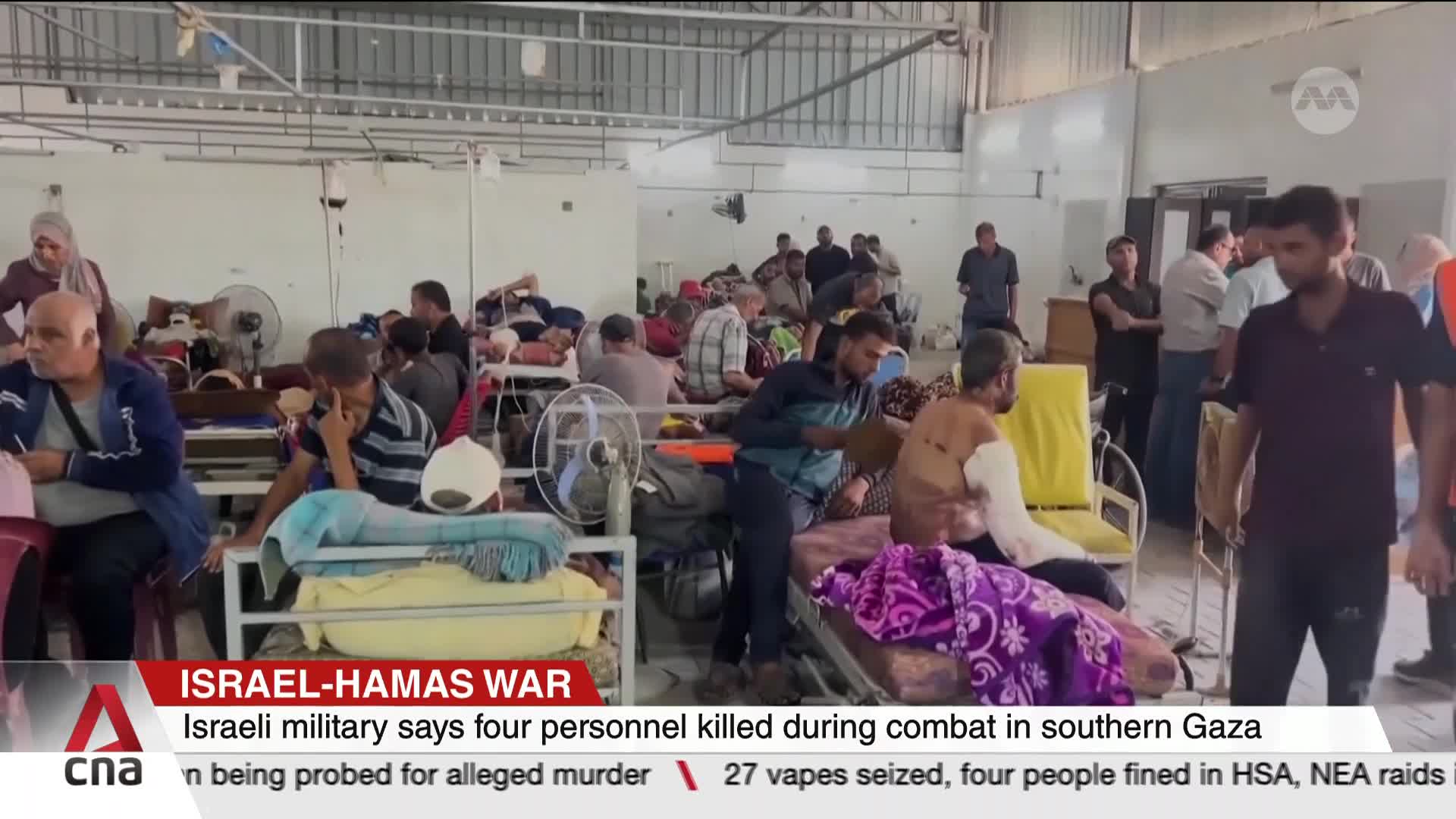 People rest on beds in a large room, some with visible injuries, while others move among them. CNA International's coverage of the Israel-Hamas war shows the aftermath of combat in Gaza.
