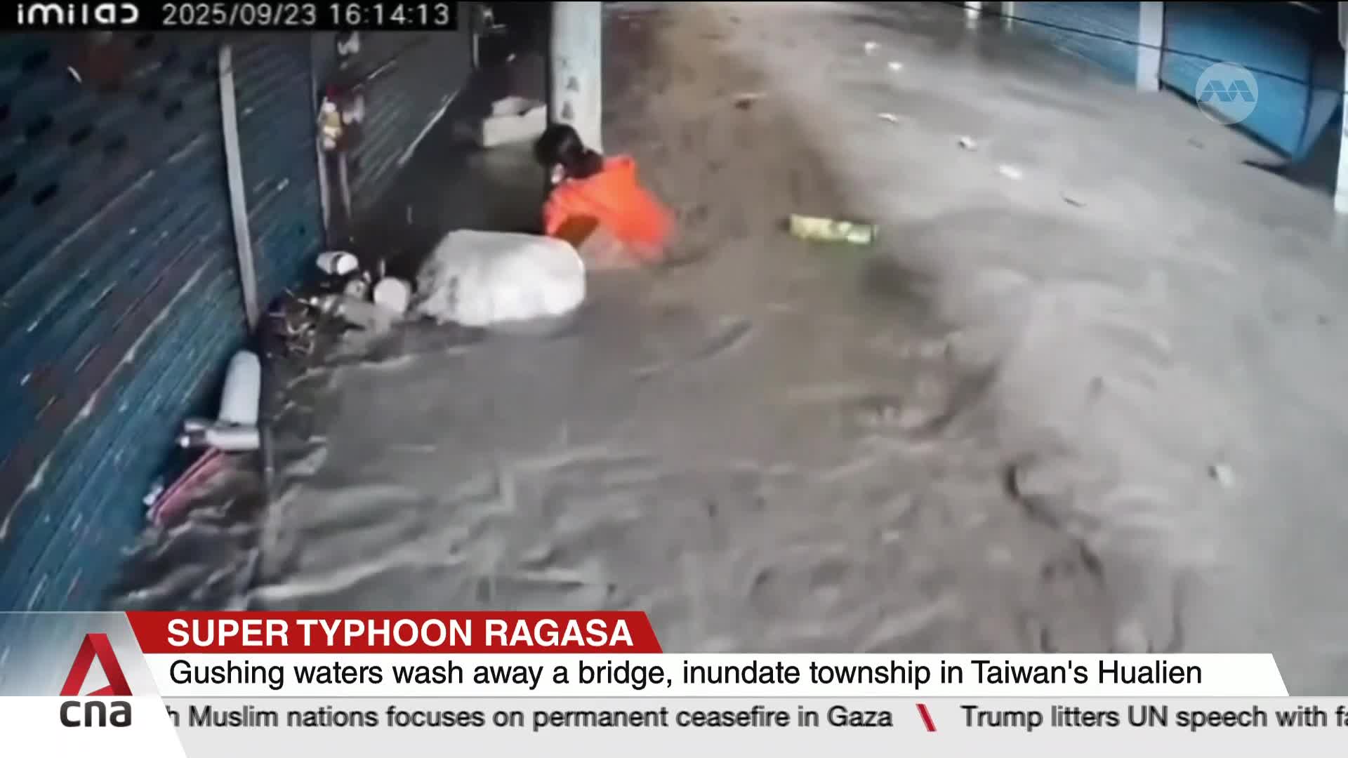 Water surges through a street, carrying debris and a person in an orange jacket. The scene, reported by CNA International, shows the impact of Super Typhoon Ragasa in Taiwan.
