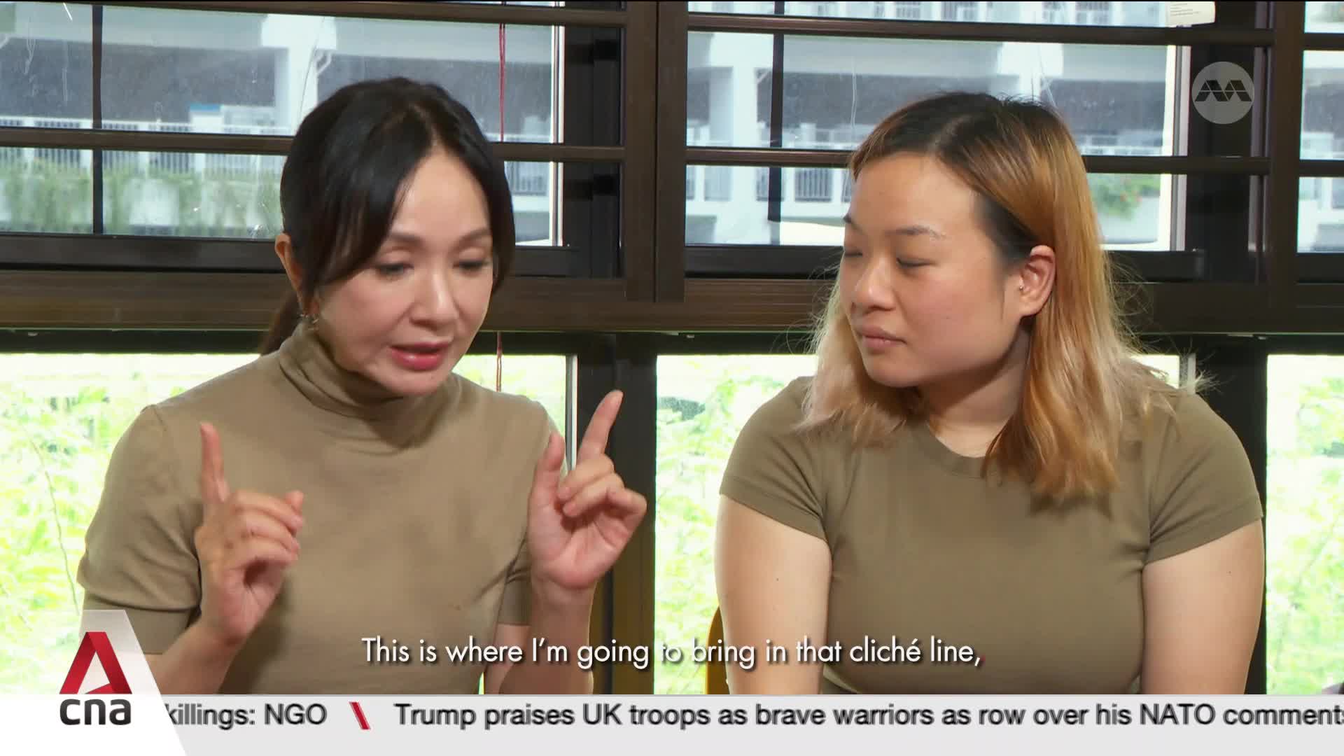 A woman with dark hair gestures with both hands as she speaks, while the woman next to her listens intently. The CNA logo appears in the lower left corner, beneath the women and a news ticker. A woman with dark hair gestures with both hands as she speaks, while the woman next to her listens intently. The CNA logo appears in the lower left corner, beneath the women and a news ticker.