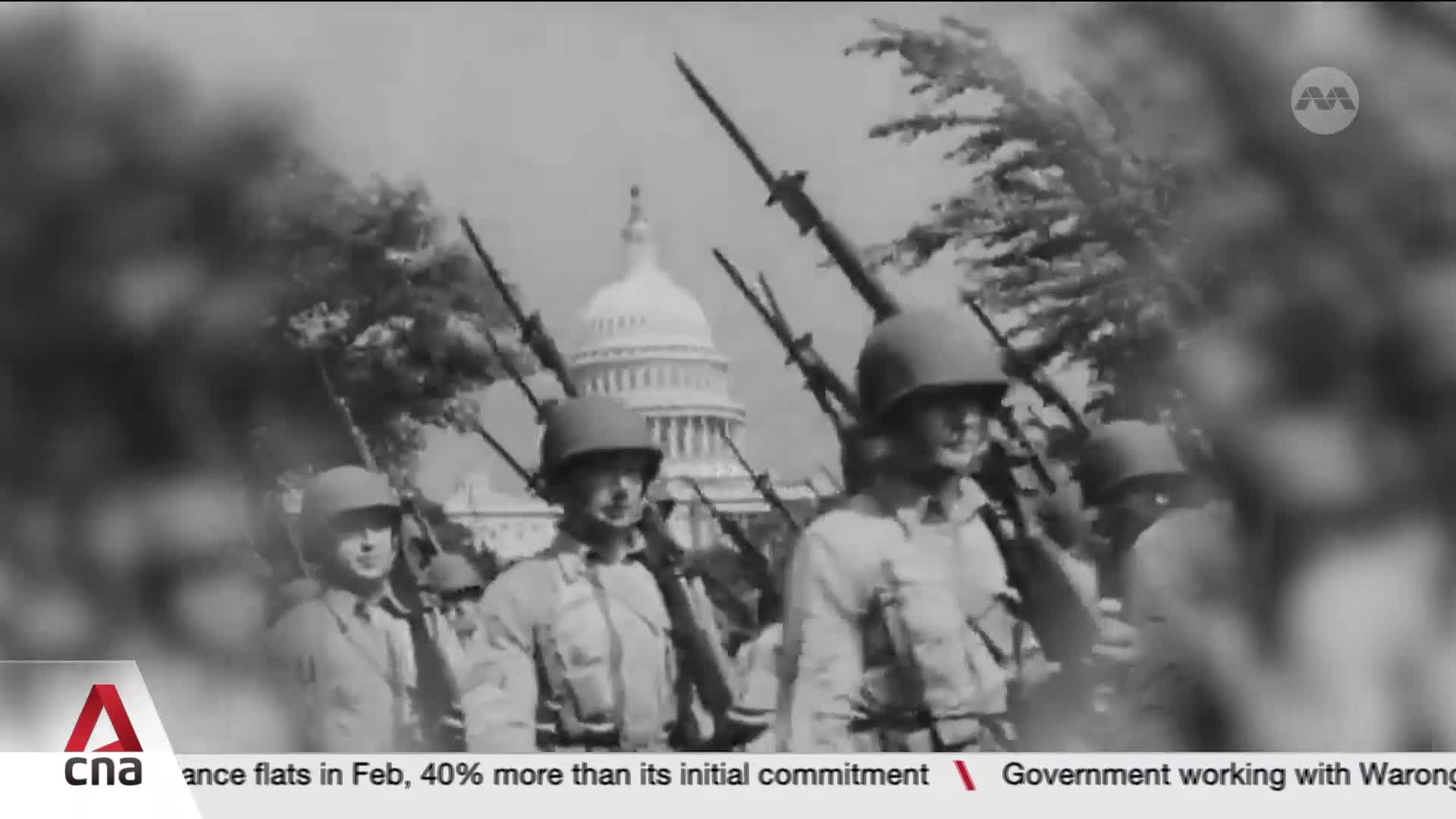 Soldiers march in formation, their rifles held at attention. The Capitol dome rises behind them, a stately backdrop to this procession. Soldiers march in formation, their rifles held at attention. The Capitol dome rises behind them, a stately backdrop to this procession.