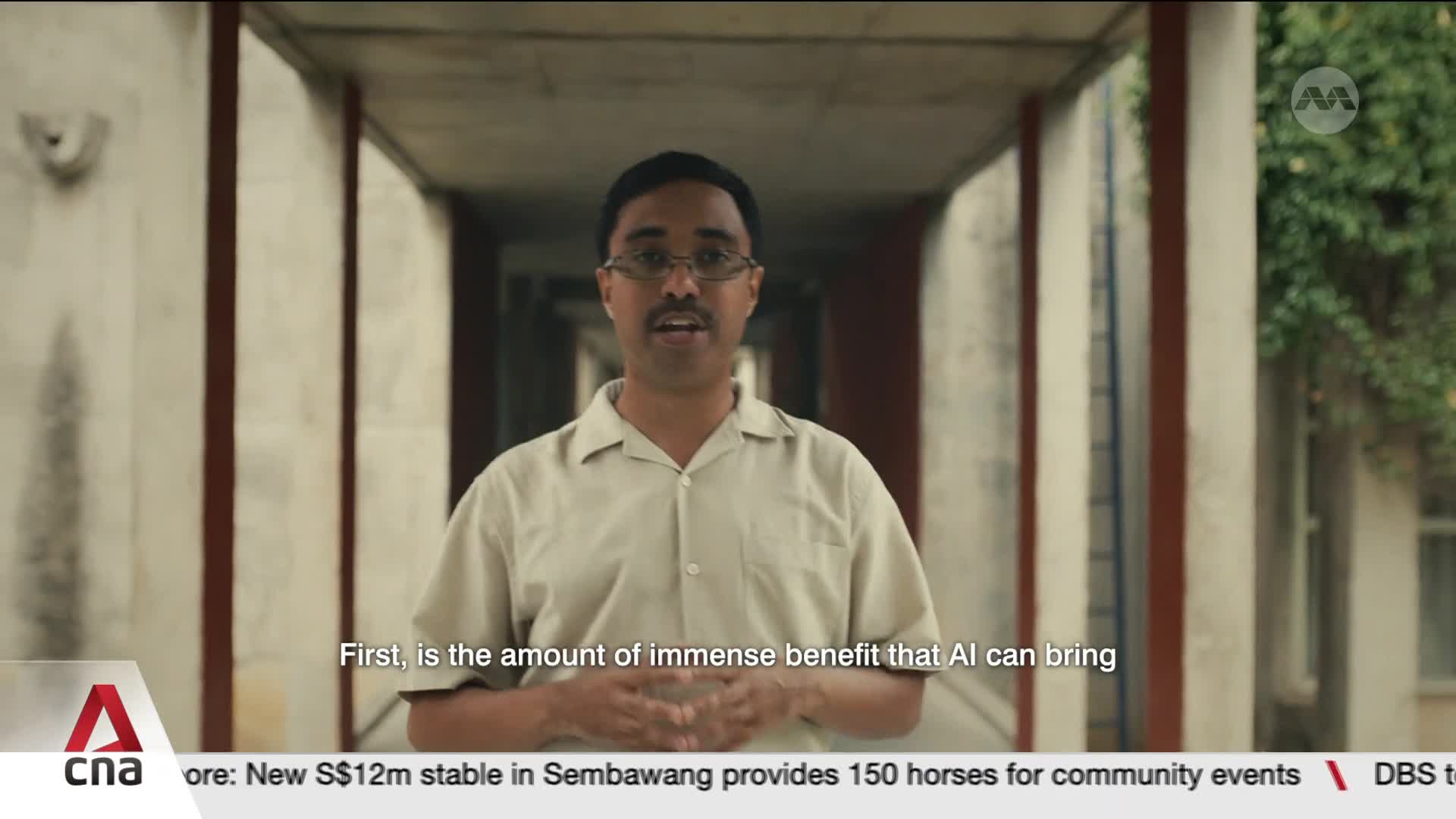 A man in a light brown shirt speaks directly to the camera, gesturing with his hands. The CNA International logo appears in the lower left corner, with a news ticker below displaying information about Sembawang. A man in a light brown shirt speaks directly to the camera, gesturing with his hands. The CNA International logo appears in the lower left corner, with a news ticker below displaying information about Sembawang.