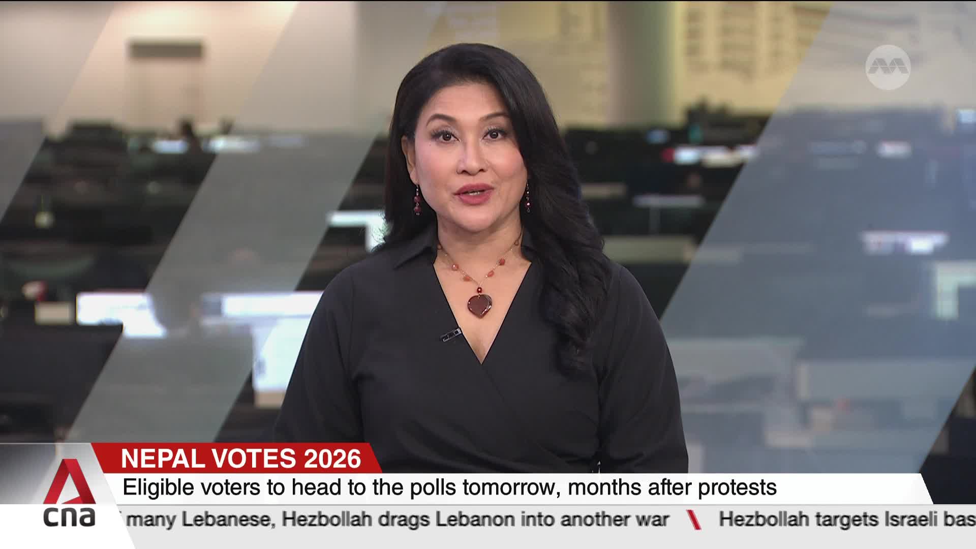 A woman in a black top speaks directly to the camera, her necklace catching the light. Behind her, a news ticker scrolls with headlines about Nepal's upcoming elections and international conflicts.